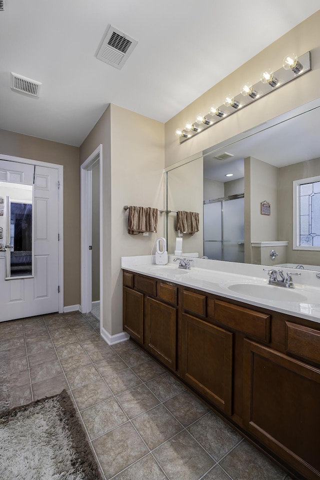 bathroom with tile patterned floors, vanity, and a shower with shower door