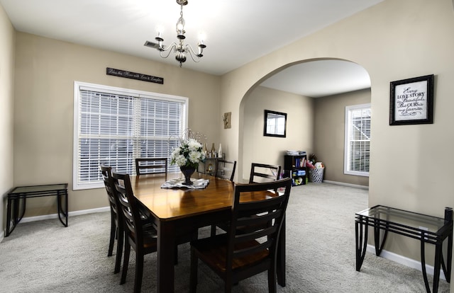 dining space with carpet and an inviting chandelier