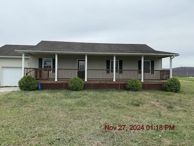 view of front of house with a porch, a garage, and a front yard