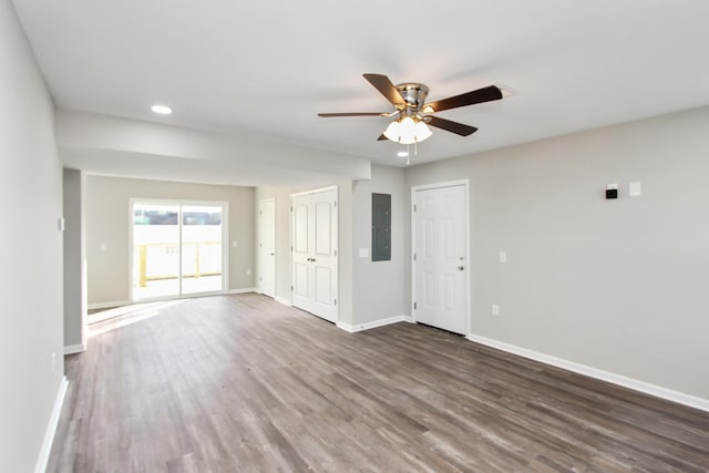 spare room with electric panel, ceiling fan, and dark hardwood / wood-style flooring