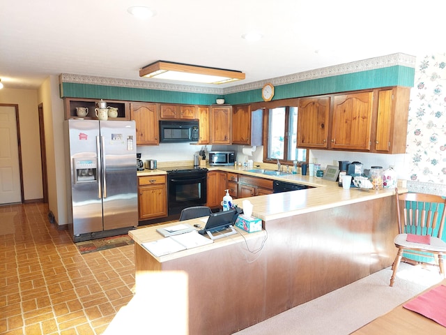 kitchen with black appliances, kitchen peninsula, and sink