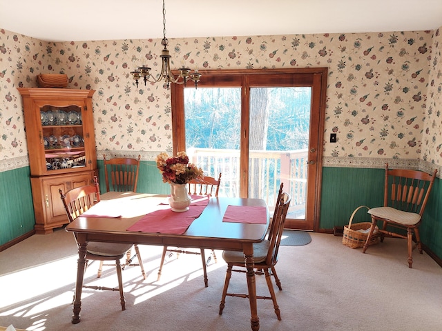 carpeted dining room with a chandelier