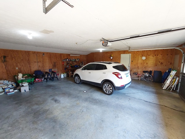 garage featuring a garage door opener and wooden walls