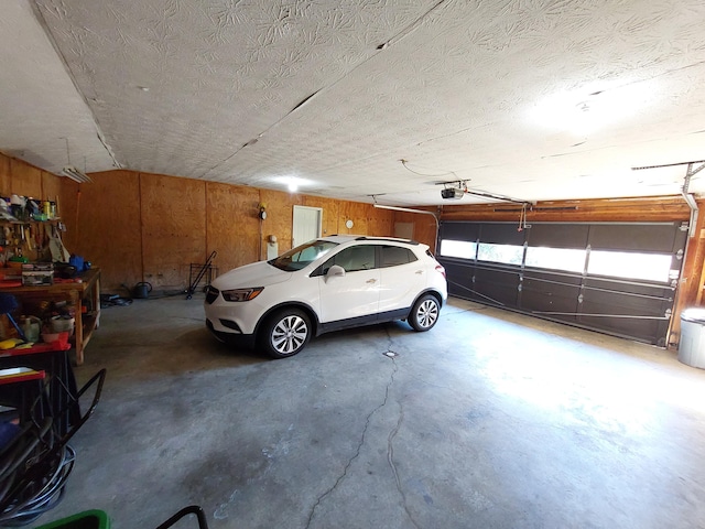 garage with wooden walls and a garage door opener