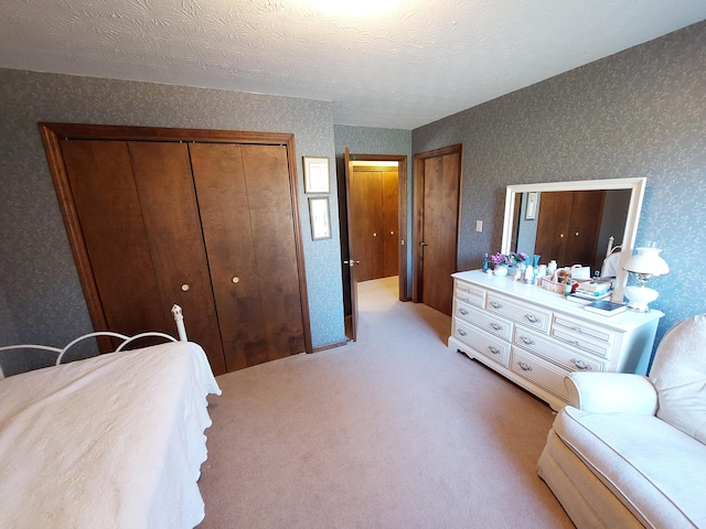 carpeted bedroom featuring a textured ceiling and a closet