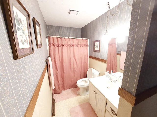 bathroom featuring vanity, toilet, and walk in shower