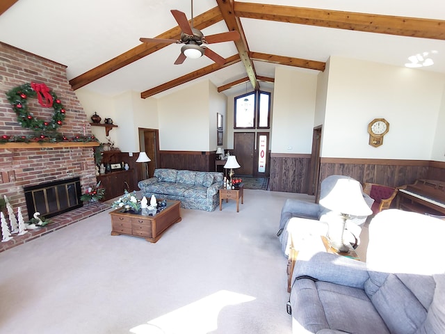 living room featuring wooden walls, a brick fireplace, vaulted ceiling with beams, ceiling fan, and carpet floors