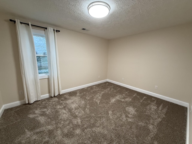 carpeted empty room featuring a textured ceiling