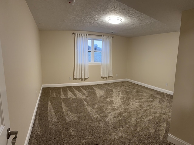 carpeted empty room with a textured ceiling