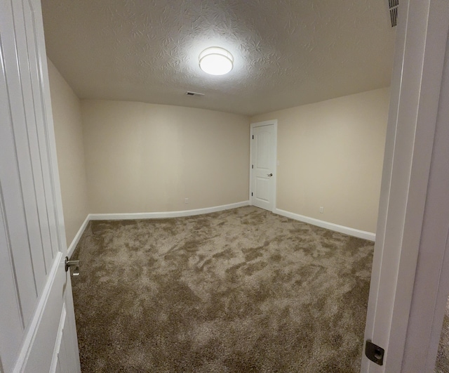 empty room with carpet flooring and a textured ceiling