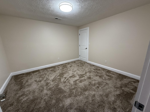 spare room featuring a textured ceiling and carpet flooring