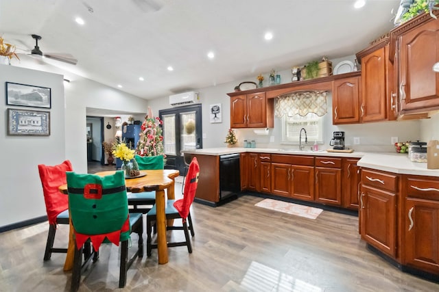 kitchen with plenty of natural light, dishwasher, light wood-type flooring, and a wall unit AC