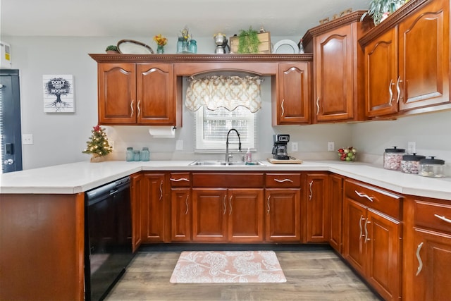 kitchen featuring kitchen peninsula, black dishwasher, light hardwood / wood-style floors, and sink