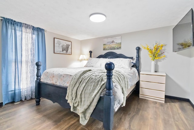 bedroom with multiple windows and dark wood-type flooring