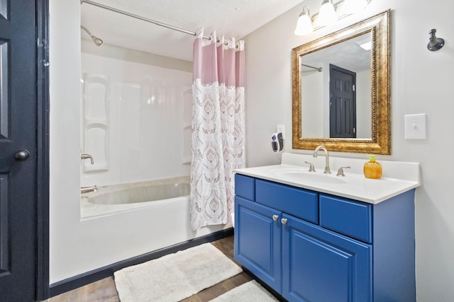 bathroom with hardwood / wood-style floors, vanity, a textured ceiling, and shower / tub combo with curtain