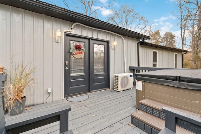 doorway to property featuring ac unit, a hot tub, and a wooden deck