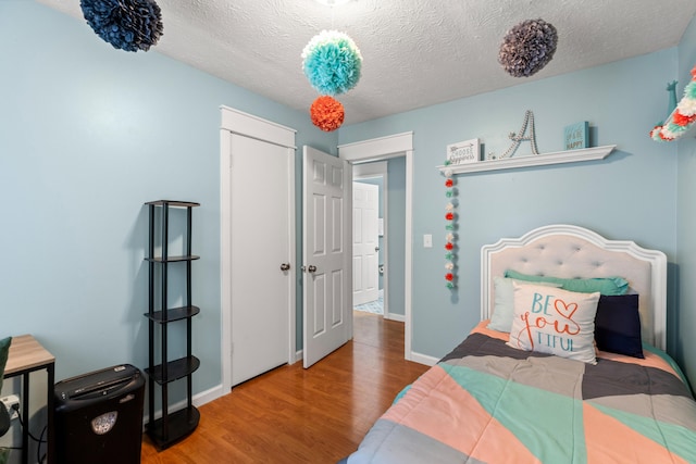 bedroom featuring a textured ceiling and hardwood / wood-style flooring