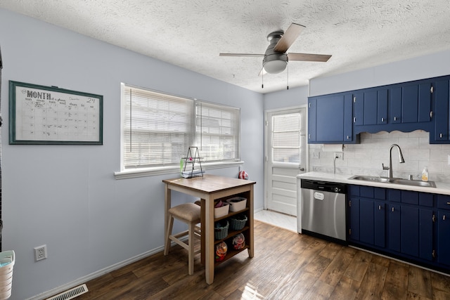 kitchen featuring dishwasher, sink, dark wood-type flooring, tasteful backsplash, and blue cabinets