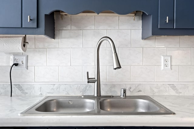 kitchen with tasteful backsplash, sink, and blue cabinets