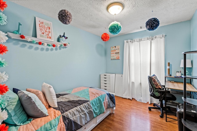 bedroom featuring hardwood / wood-style floors and a textured ceiling