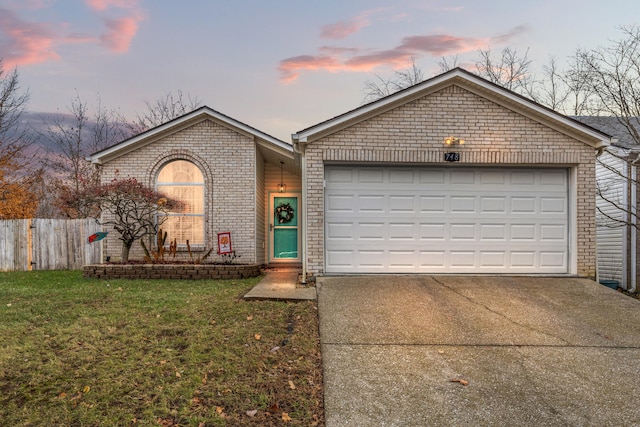 single story home featuring a lawn and a garage