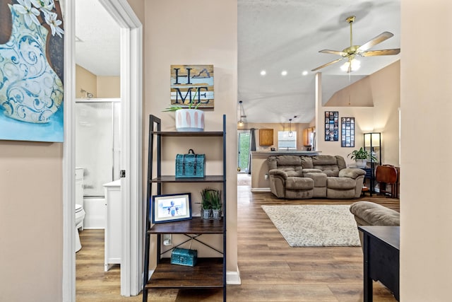 living room featuring hardwood / wood-style floors, ceiling fan, and a textured ceiling