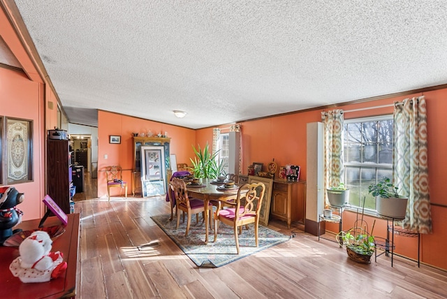 dining space with wood-type flooring and a textured ceiling