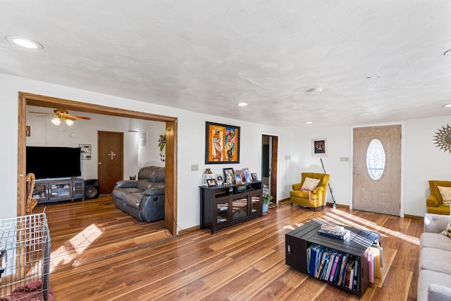 living room with ceiling fan, hardwood / wood-style floors, and a textured ceiling