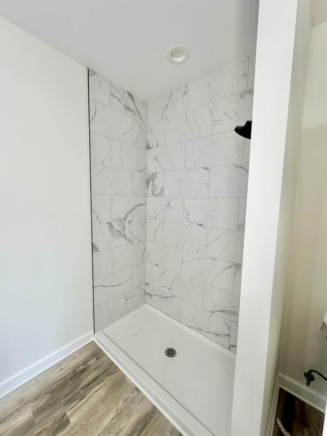 bathroom featuring hardwood / wood-style floors and a tile shower