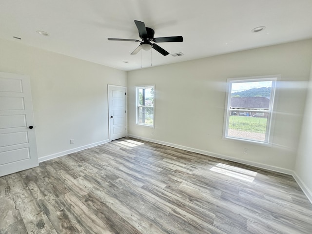 spare room featuring ceiling fan, plenty of natural light, and light hardwood / wood-style flooring