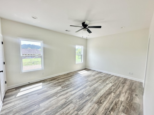 unfurnished room featuring light hardwood / wood-style flooring, plenty of natural light, and ceiling fan