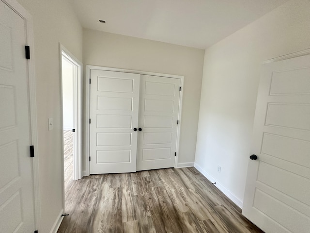 unfurnished bedroom with a closet and hardwood / wood-style flooring