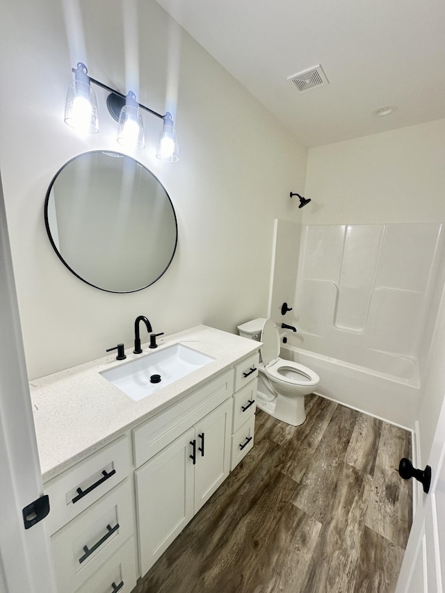 full bathroom featuring vanity, wood-type flooring, bathtub / shower combination, and toilet