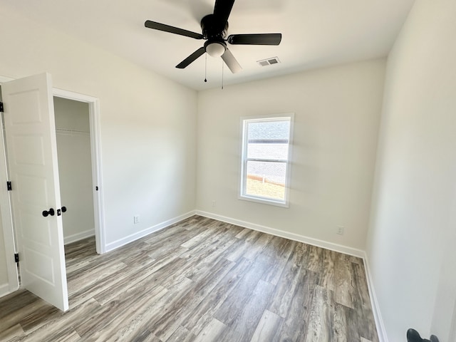 unfurnished bedroom with a closet, light hardwood / wood-style floors, and ceiling fan