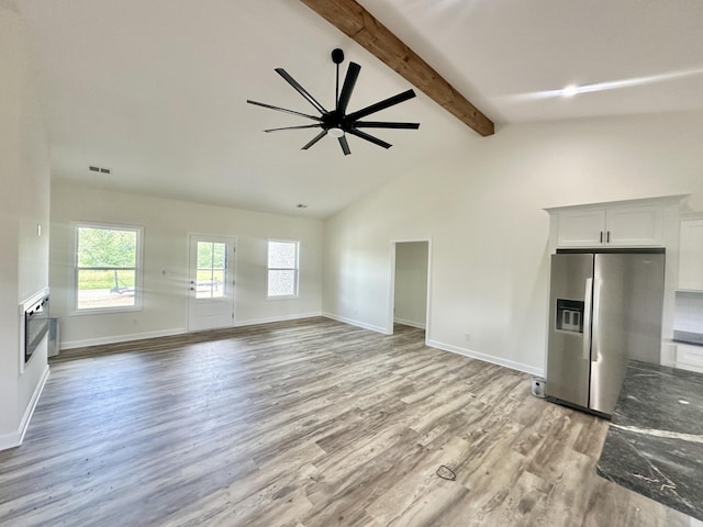 unfurnished living room featuring ceiling fan, beam ceiling, wood-type flooring, and high vaulted ceiling