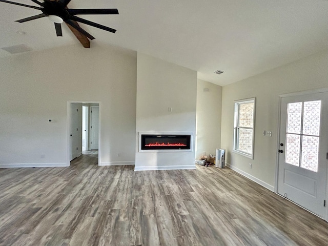 unfurnished living room featuring light wood-type flooring, vaulted ceiling, and ceiling fan