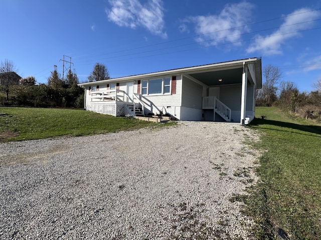 manufactured / mobile home with a carport and a front yard