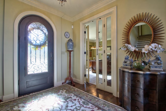 entryway featuring arched walkways, french doors, crown molding, wood finished floors, and baseboards