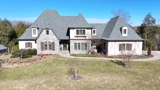 view of front facade with stone siding, a high end roof, and a front lawn