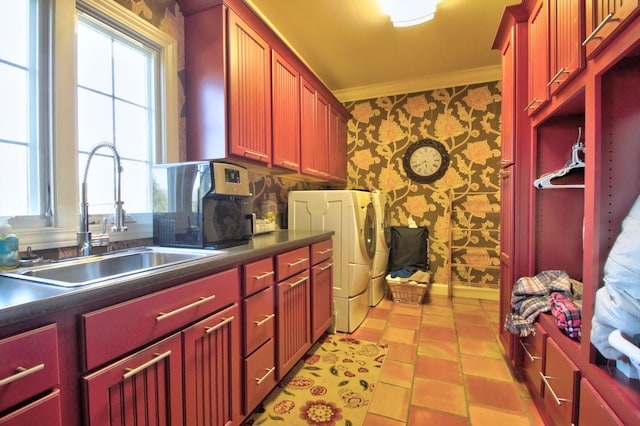 laundry room with a sink, independent washer and dryer, cabinet space, wallpapered walls, and crown molding