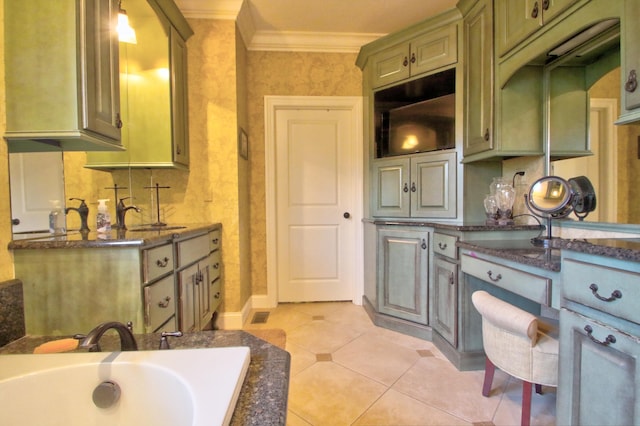 kitchen featuring light tile patterned flooring, a sink, green cabinets, dark stone counters, and crown molding