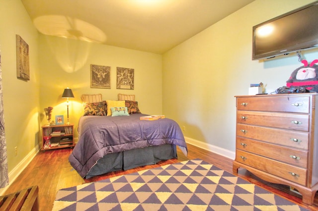 bedroom featuring baseboards and wood finished floors