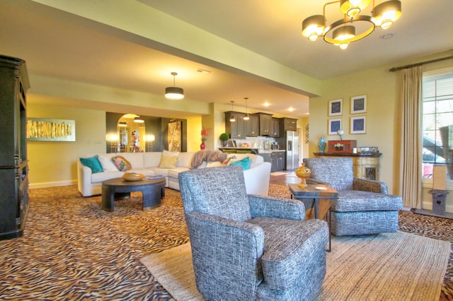 carpeted living room featuring an inviting chandelier and baseboards