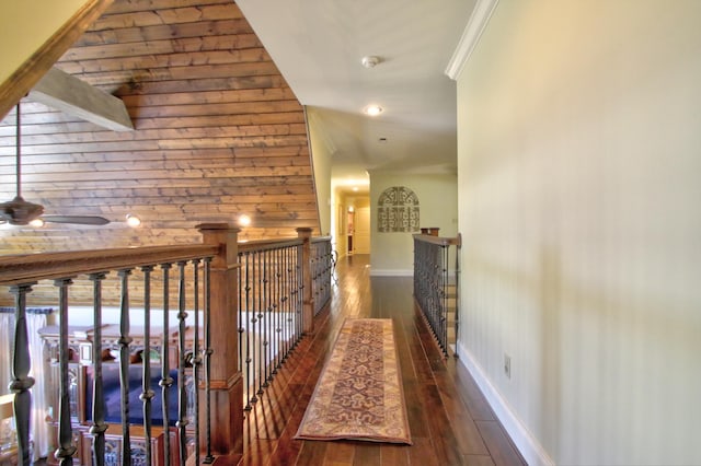 hall featuring an upstairs landing, baseboards, crown molding, and hardwood / wood-style floors