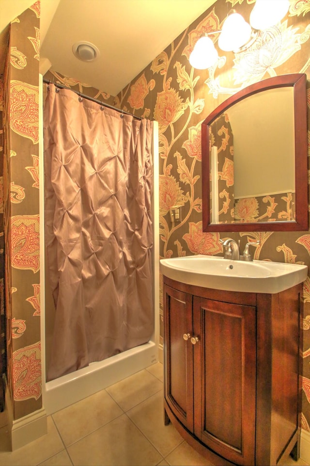 full bathroom featuring wallpapered walls, tile patterned flooring, vanity, and a stall shower