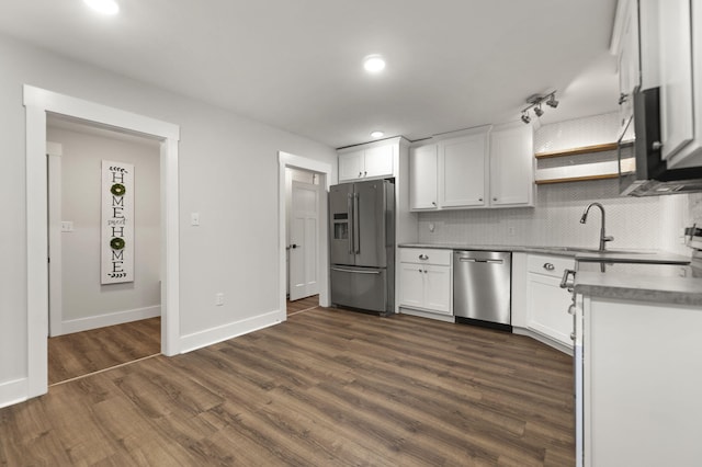 kitchen featuring decorative backsplash, dark hardwood / wood-style flooring, stainless steel appliances, sink, and white cabinets