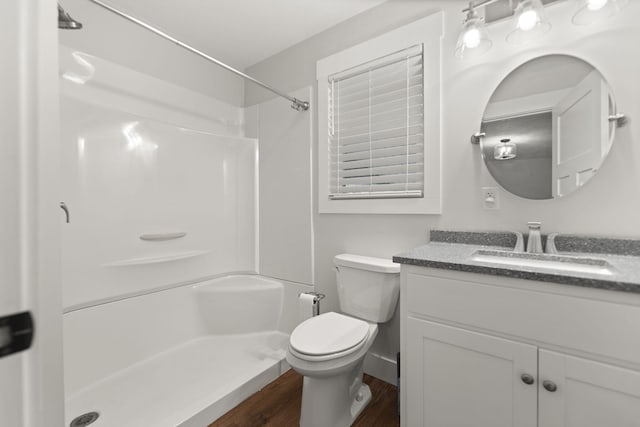 bathroom featuring a shower, hardwood / wood-style floors, vanity, and toilet