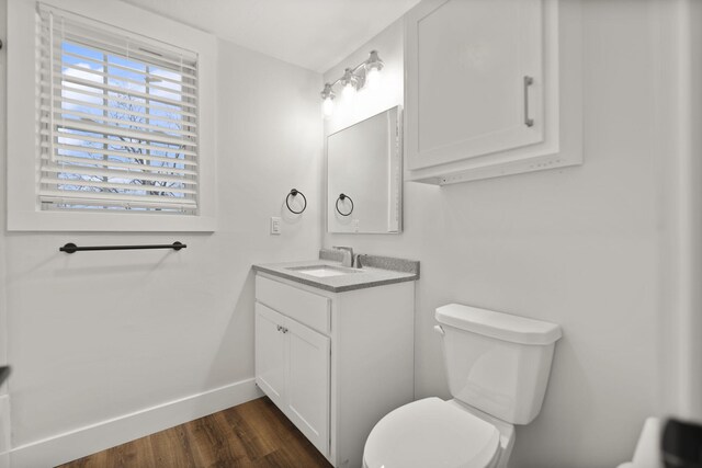 bathroom with hardwood / wood-style floors, vanity, and toilet