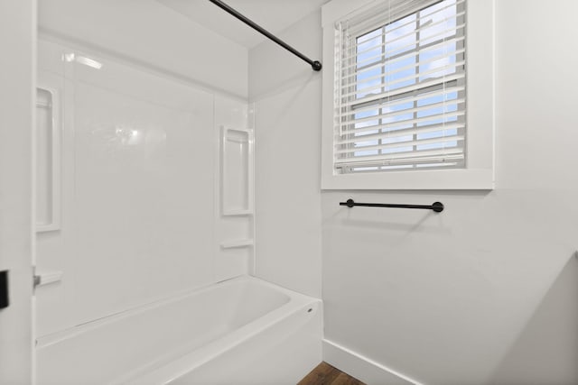 bathroom featuring wood-type flooring and bathing tub / shower combination