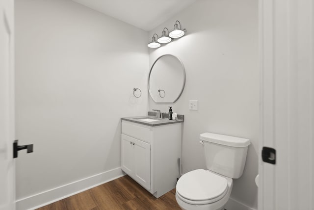 bathroom with vanity, toilet, and wood-type flooring